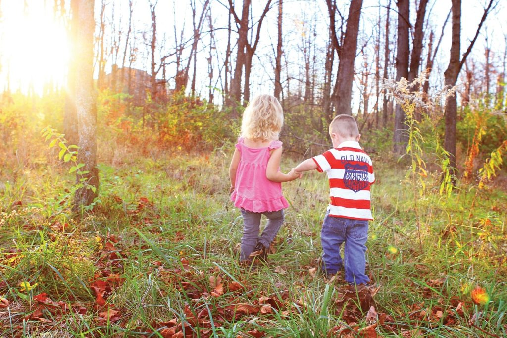 2 kids playing in the forest