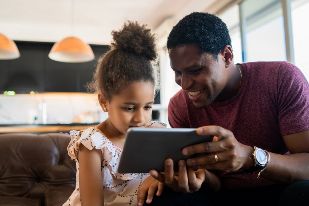 father and daughter using tablet at home
